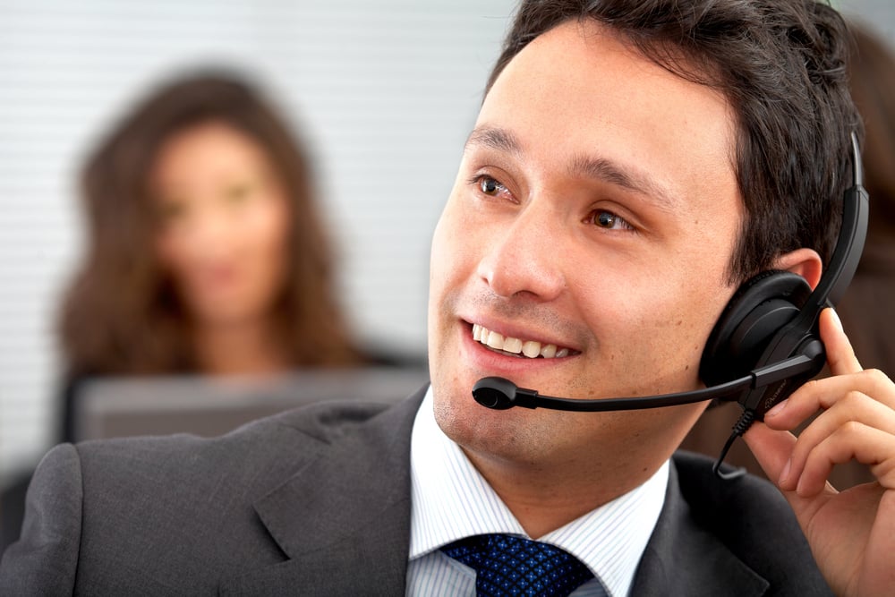 male customer service representative smiling in an office
